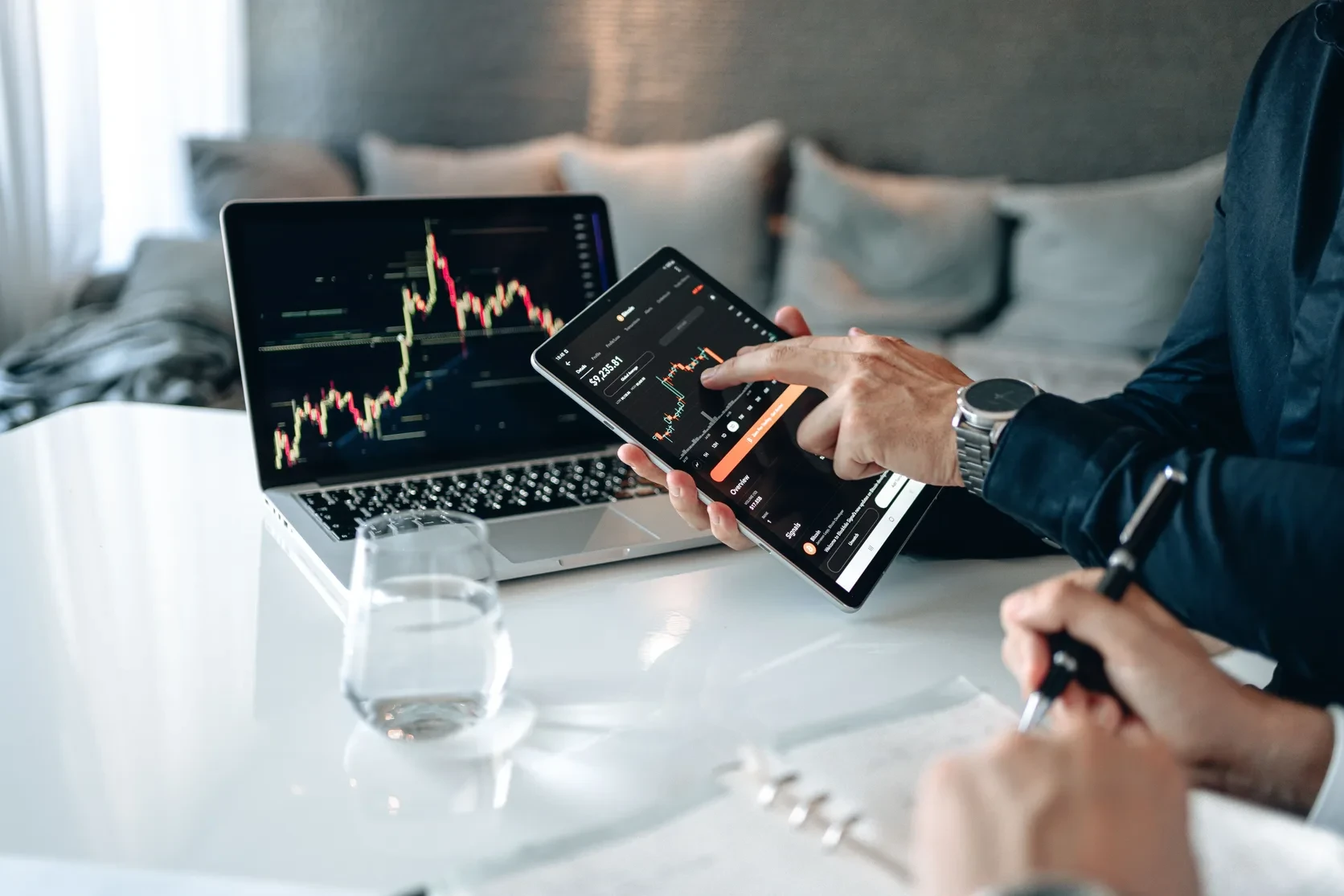 Tablet and laptop showing financial charts during a fintech discussion